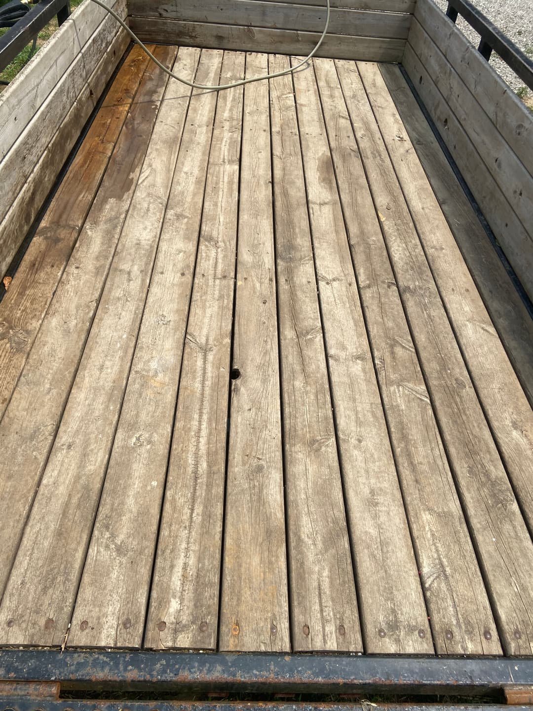 Wooden trailer bed with weathered planks and a clean, empty surface. Ideal for hauling.
