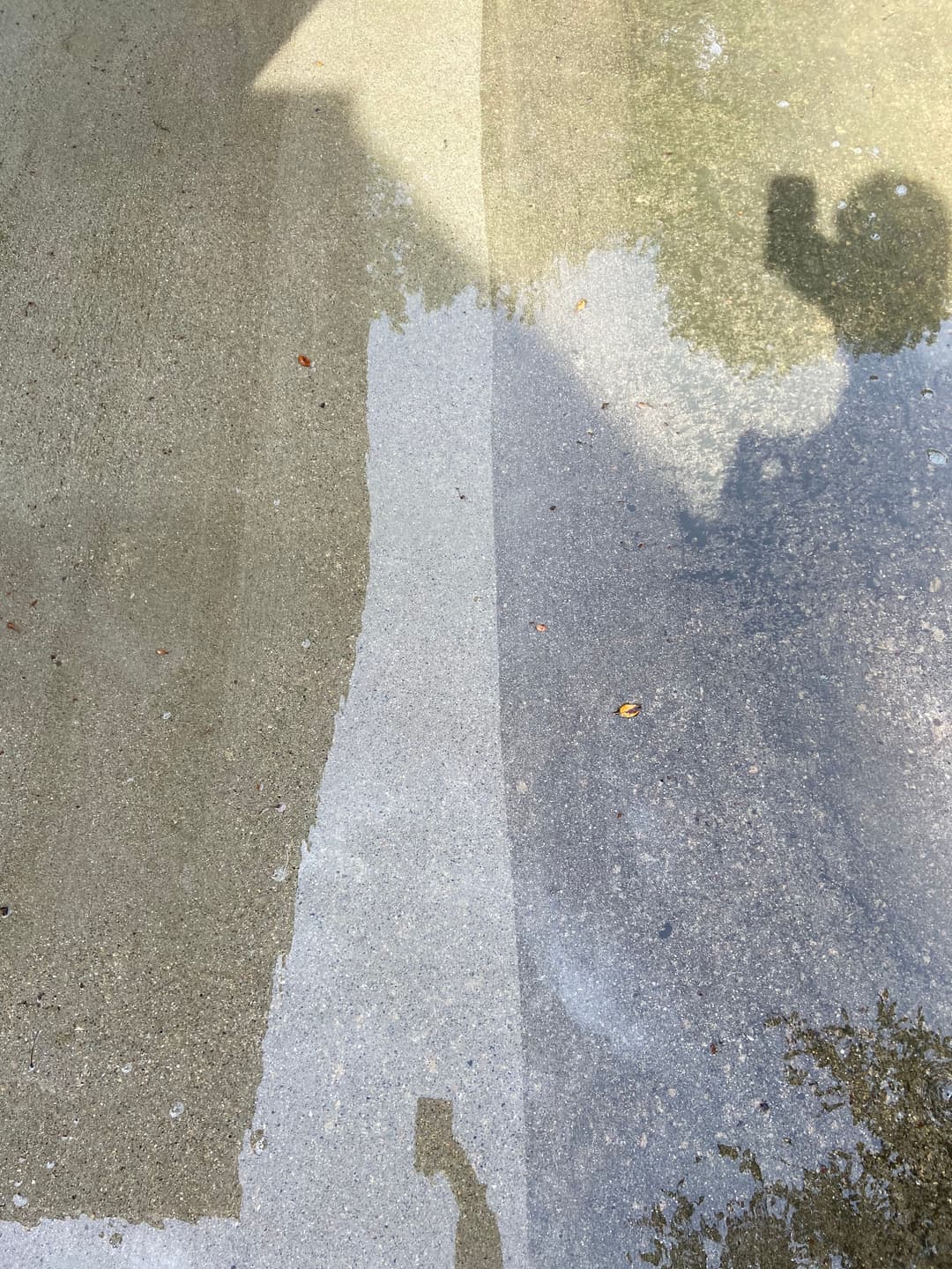 Wet concrete surface showing distinct water patterns and shadows.