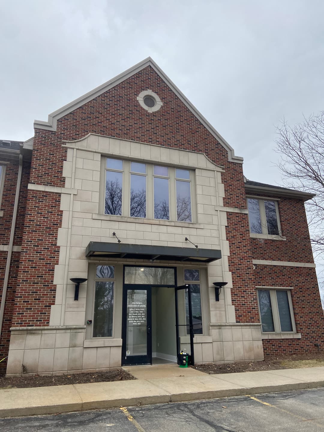 Brick commercial building with large windows and a decorative gable entrance.
