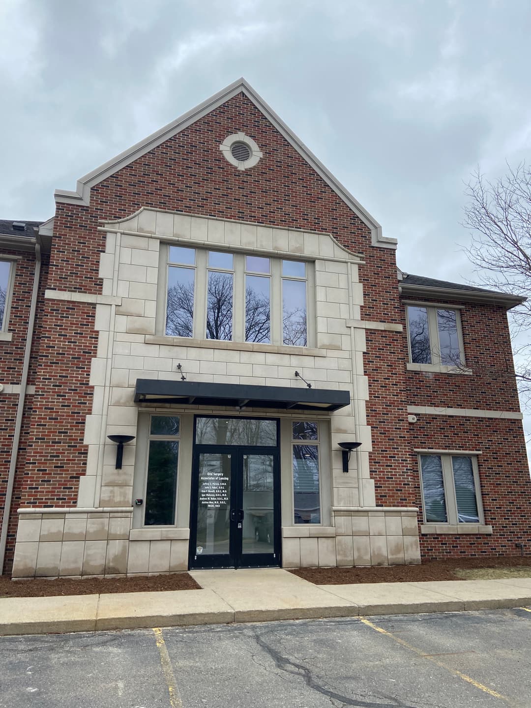 Modern brick building facade with large windows and a prominent entrance.